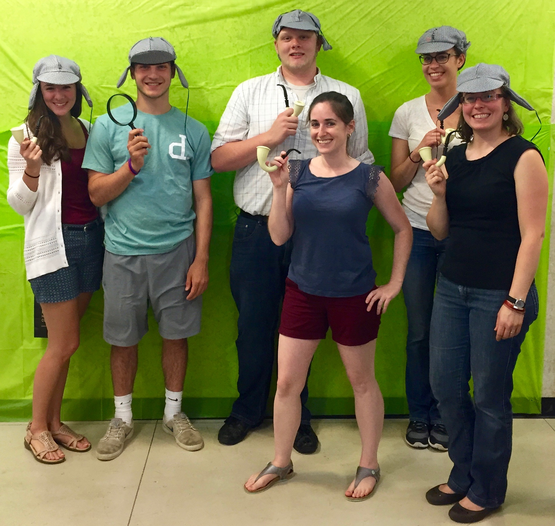 Hurley lab in detective hats holding magnifying glasses and large pipes